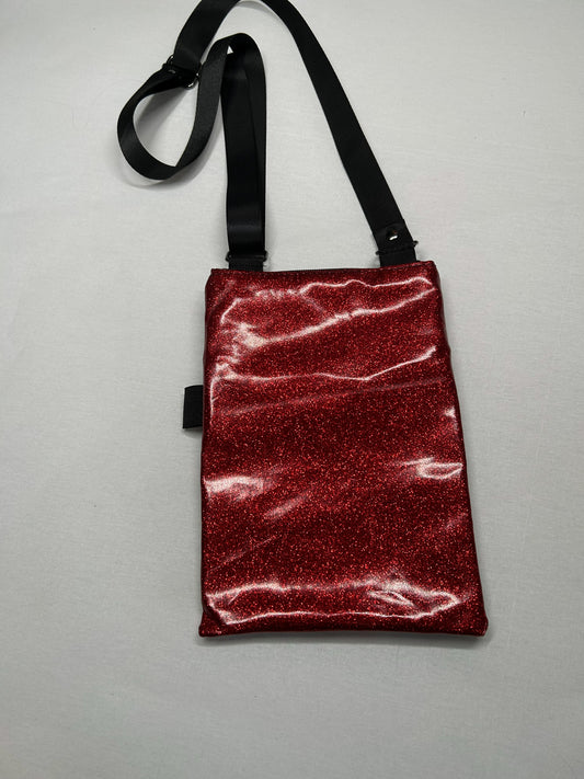 A red glittery handbag with a black strap is shown against a white background.