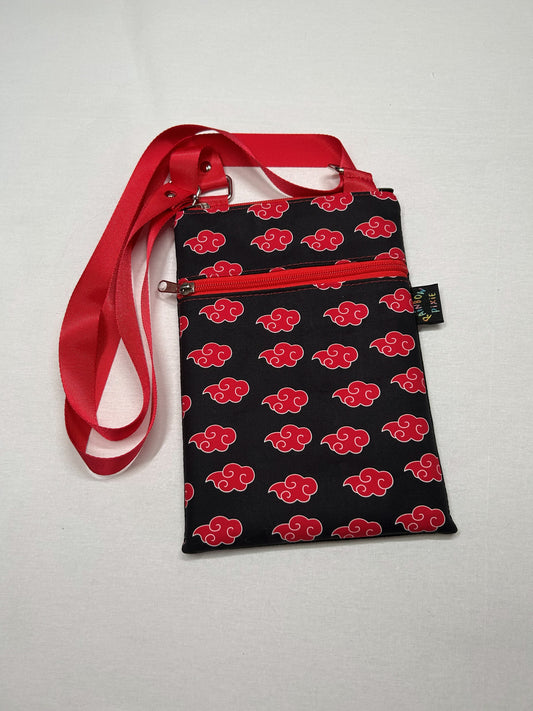A black and red patterned bag with a red strap, featuring a repeating pattern of red clouds on a black background.