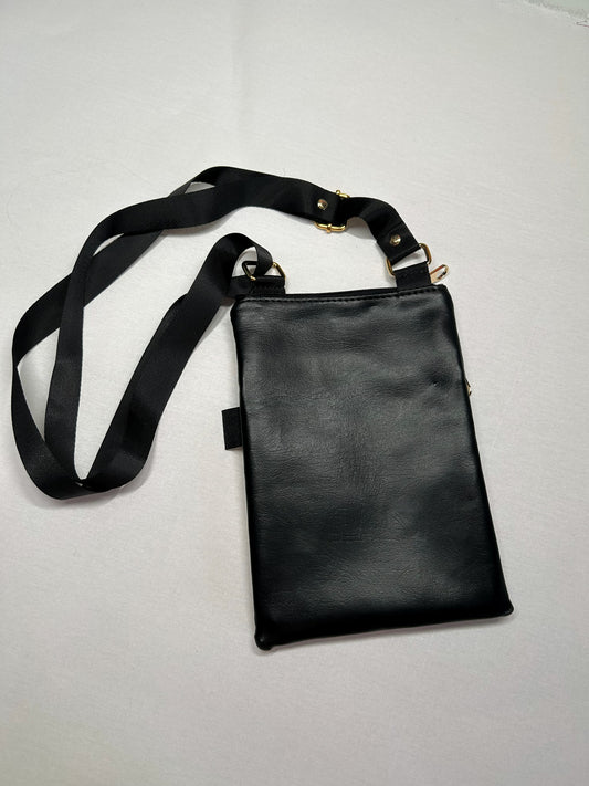 A black leather crossbody bag with a black strap and gold hardware is shown on a white surface.