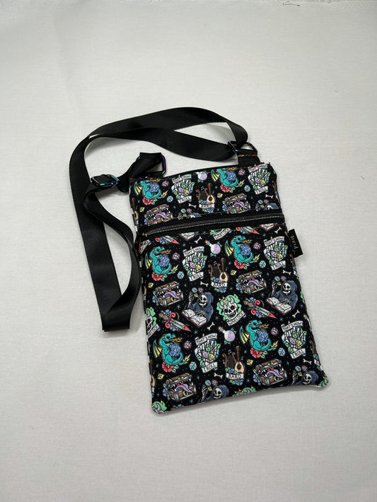 A colorful, patterned purse with various illustrations and designs on it, including skulls, bats, and other symbols.