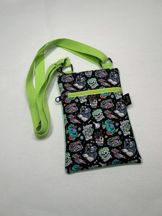 A colorful, patterned purse with a green strap is shown on a white surface.