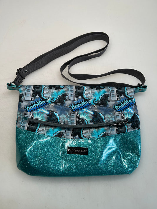 Godzilla Themed foldover crossbody bag with blue glitter bottom