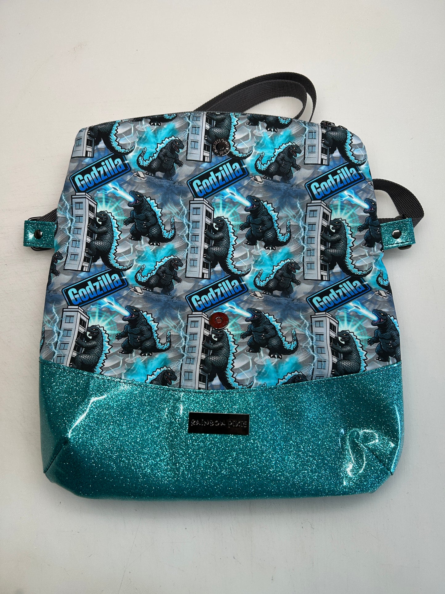 Godzilla Themed foldover crossbody bag with blue glitter bottom