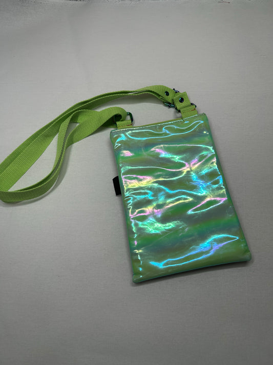 A green, shiny, and iridescent handbag with a green strap is displayed on a white surface.